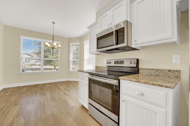 kitchen featuring light wood-style floors, appliances with stainless steel finishes, white cabinets, and a notable chandelier