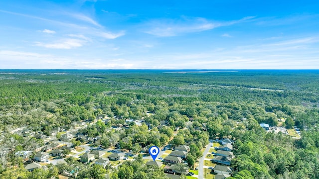 drone / aerial view with a wooded view