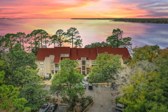 aerial view at dusk featuring a water view