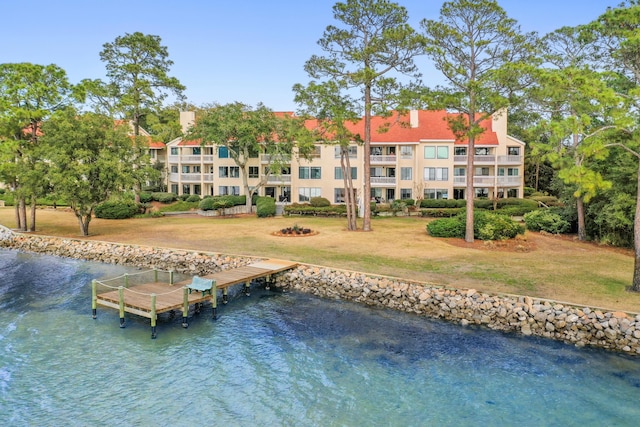 view of dock featuring a water view and a yard