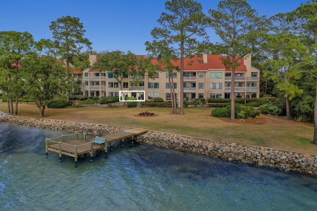 dock area with a water view and a yard