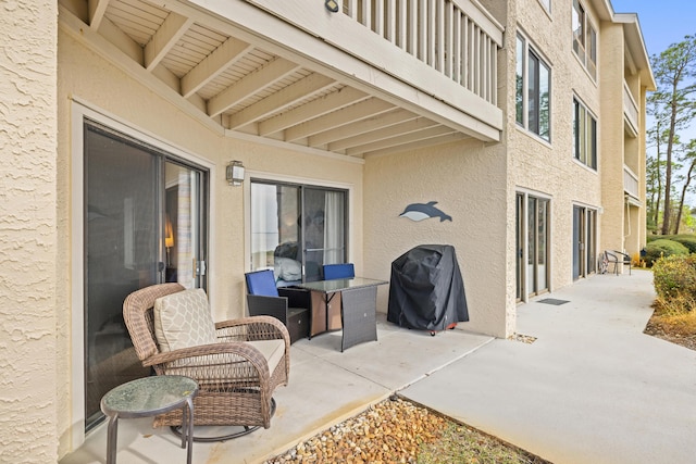 view of patio featuring a balcony and a grill