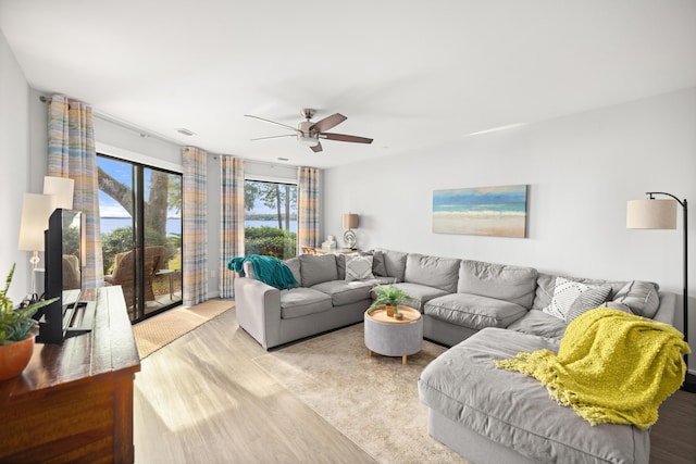 living area featuring a ceiling fan, visible vents, and wood finished floors