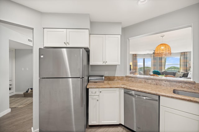 kitchen featuring visible vents, stainless steel appliances, wood finished floors, and white cabinetry