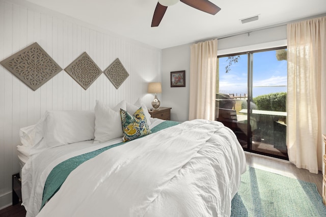 bedroom featuring a ceiling fan, access to outside, visible vents, and wood finished floors