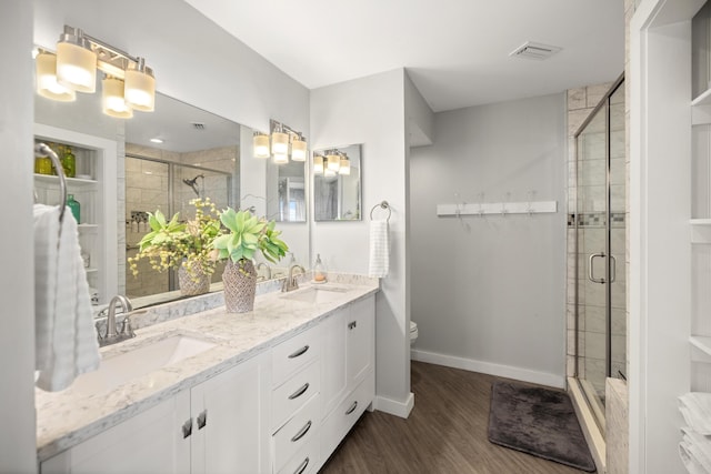 bathroom featuring visible vents, a sink, a shower stall, and baseboards