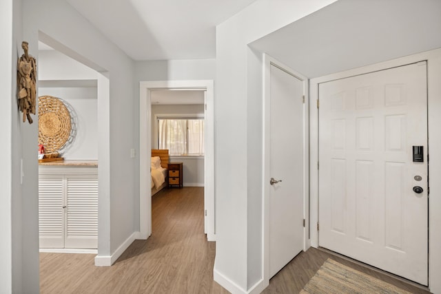 foyer entrance with wood finished floors and baseboards