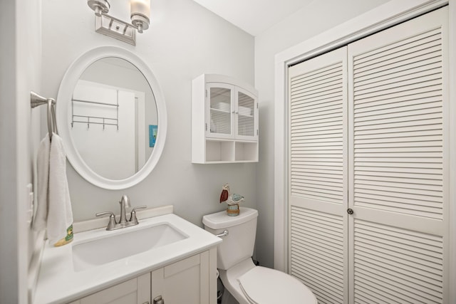 half bathroom with vanity and toilet