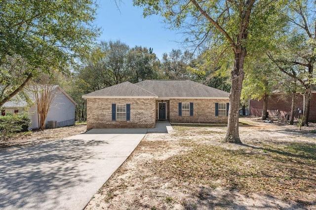 ranch-style home featuring brick siding and central AC unit