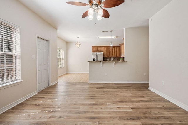 132 Lonnie Jack Dr, Crestview, FL 32536 - unfurnished living room featuring baseboards, light wood-type flooring, a ceiling fan, and a sink