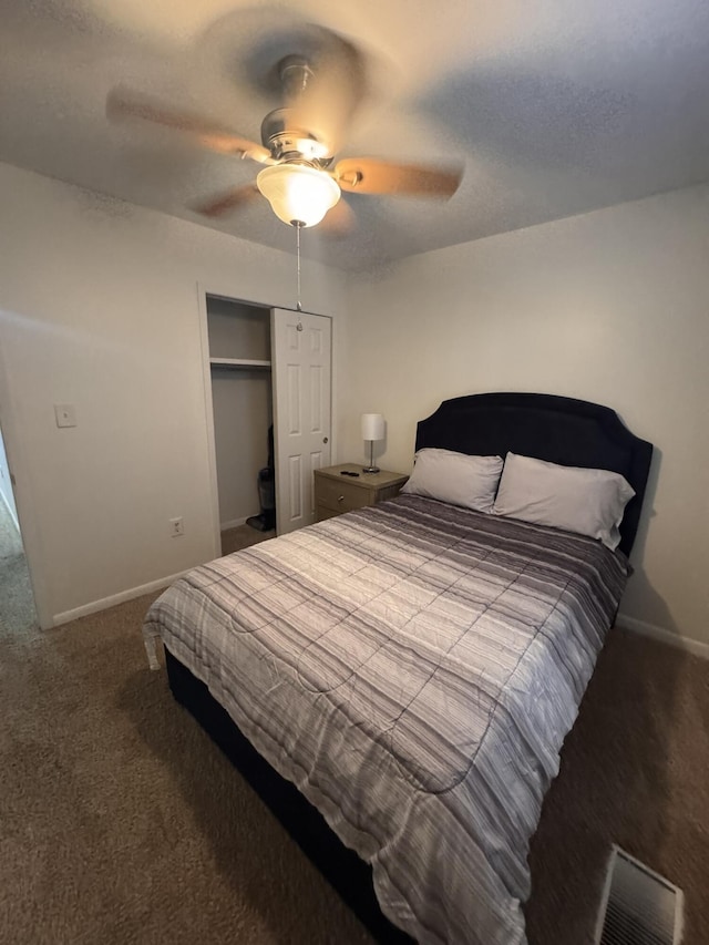 carpeted bedroom with visible vents, a ceiling fan, a textured ceiling, a closet, and baseboards