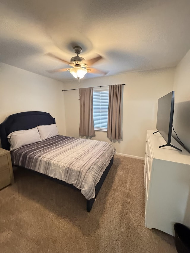 carpeted bedroom featuring baseboards and ceiling fan