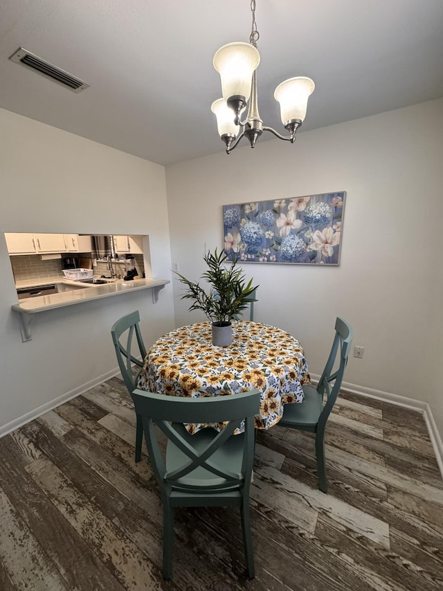 dining space featuring visible vents, baseboards, a notable chandelier, and dark wood-style floors