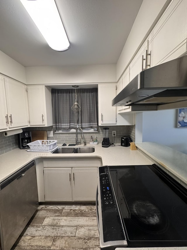 kitchen with a sink, stainless steel dishwasher, under cabinet range hood, and white cabinets