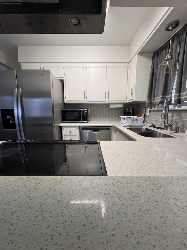 kitchen featuring a sink, white cabinets, tasteful backsplash, and stainless steel appliances