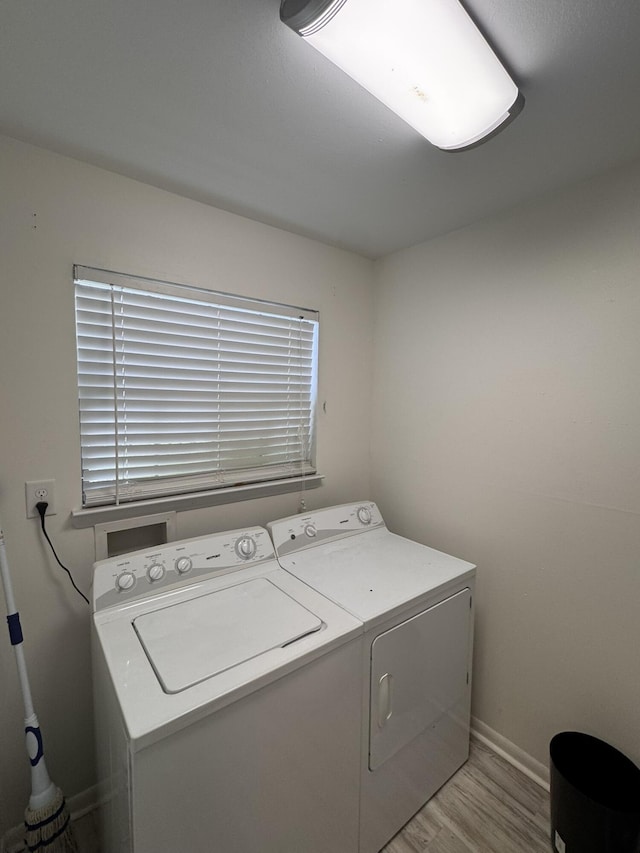 laundry room with baseboards, separate washer and dryer, laundry area, and light wood finished floors