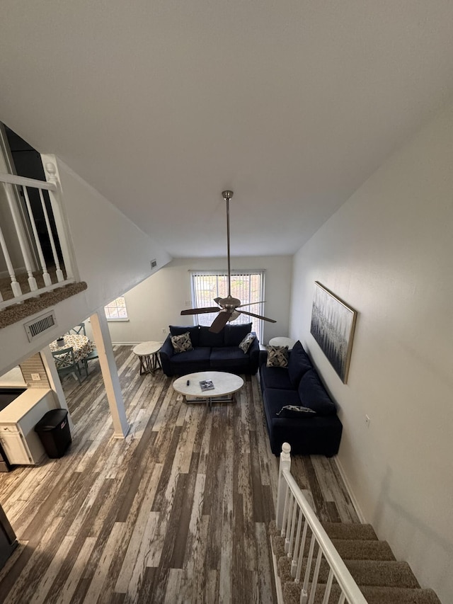 living area with vaulted ceiling, visible vents, and wood finished floors