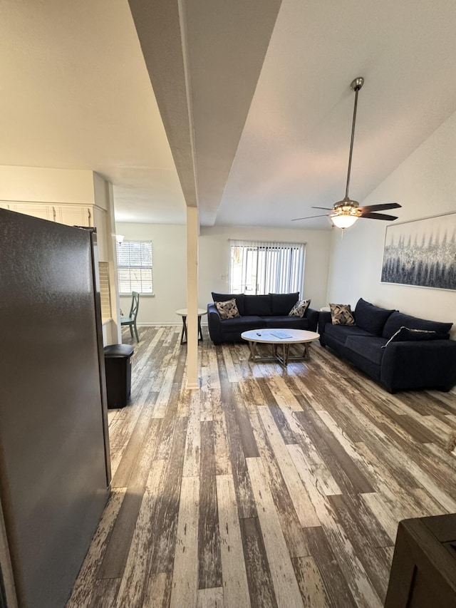 living area featuring a ceiling fan, lofted ceiling, and wood finished floors