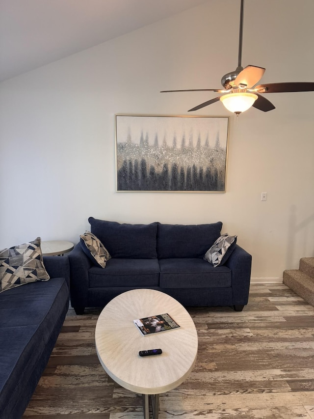 living room featuring a ceiling fan, lofted ceiling, stairway, and wood finished floors