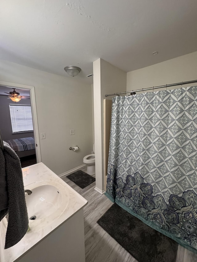 bathroom with vanity, wood finished floors, ensuite bath, curtained shower, and toilet