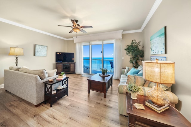 living area with light wood finished floors, a ceiling fan, and crown molding