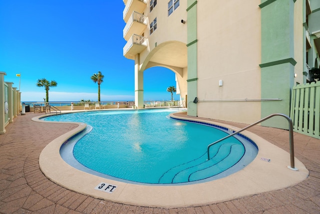 community pool featuring a patio and fence