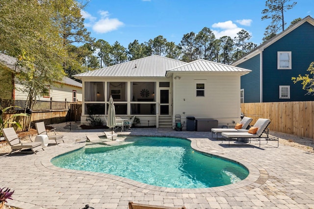 back of property featuring a patio area, metal roof, a fenced backyard, and a sunroom