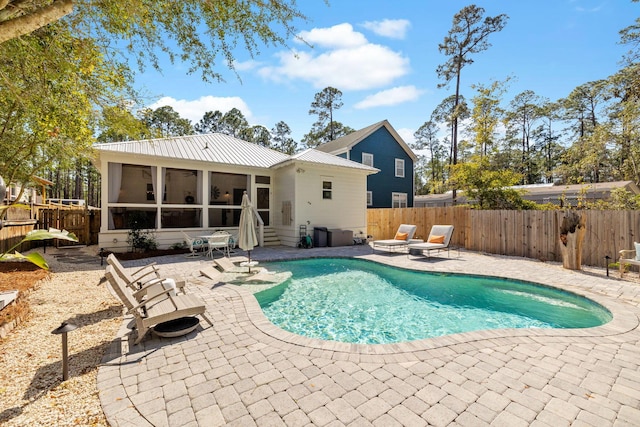 view of swimming pool with a patio area, a fenced in pool, a fenced backyard, and a sunroom