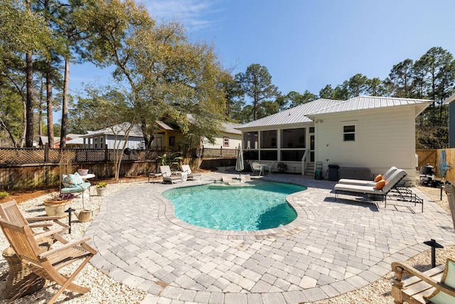 view of swimming pool featuring a fenced backyard, a fenced in pool, a patio, and a sunroom