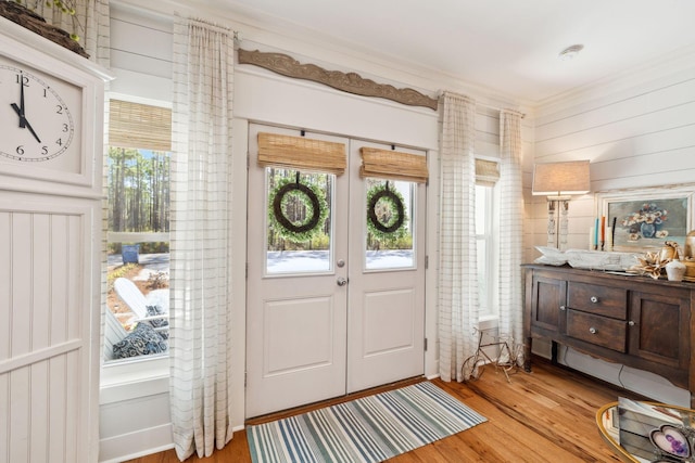 entryway featuring light wood-style floors, french doors, and a healthy amount of sunlight