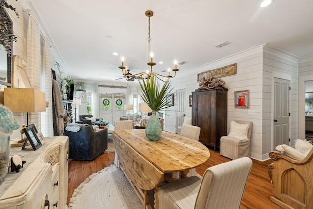 dining space featuring recessed lighting, light wood-style floors, an inviting chandelier, and crown molding