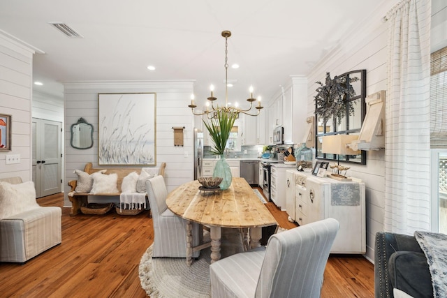 dining area with visible vents, crown molding, a chandelier, recessed lighting, and light wood-style floors