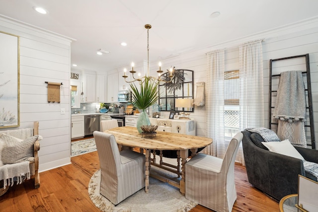 dining space with a wealth of natural light, light wood-style floors, and a chandelier