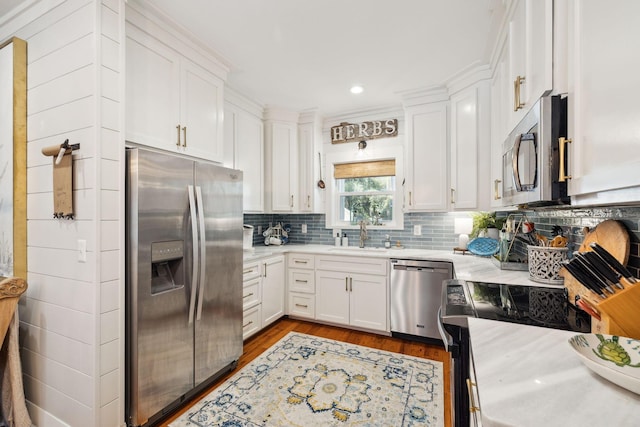 kitchen with a sink, stainless steel appliances, white cabinets, and light countertops