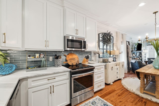 kitchen featuring stainless steel appliances, white cabinets, and light wood finished floors