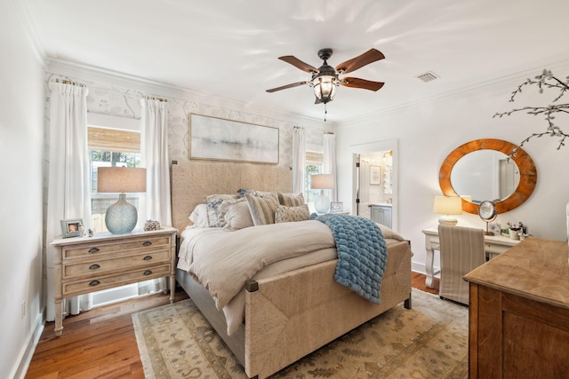 bedroom featuring baseboards, visible vents, light wood finished floors, and ornamental molding