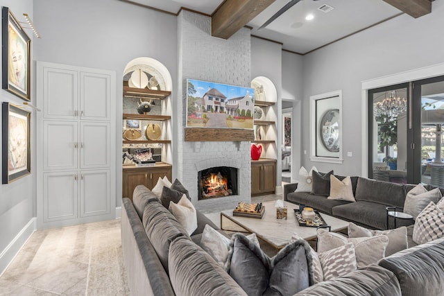 living area with built in shelves, a fireplace, visible vents, baseboards, and beamed ceiling