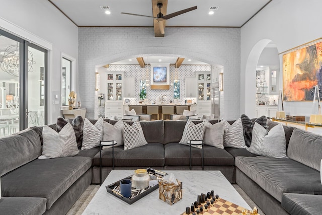 living area featuring a ceiling fan, arched walkways, visible vents, and recessed lighting