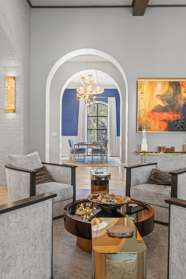 living area featuring brick wall, arched walkways, and a notable chandelier