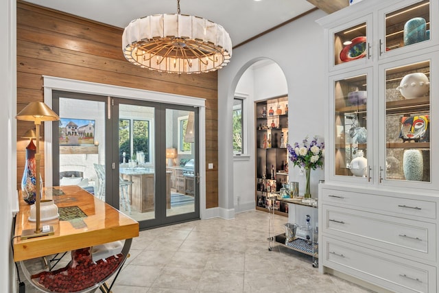 doorway to outside with light tile patterned floors, baseboards, arched walkways, and french doors