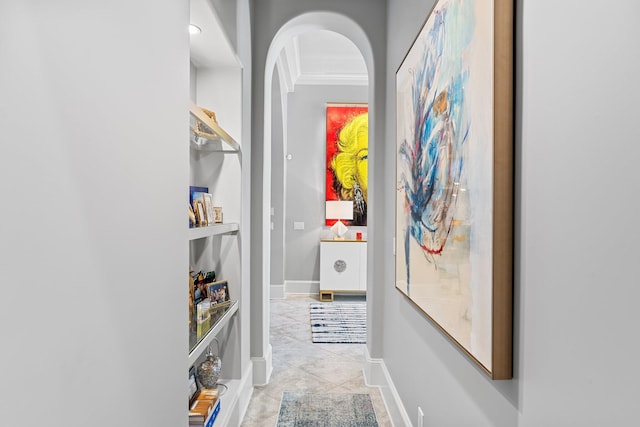 hallway featuring arched walkways, baseboards, and light tile patterned floors