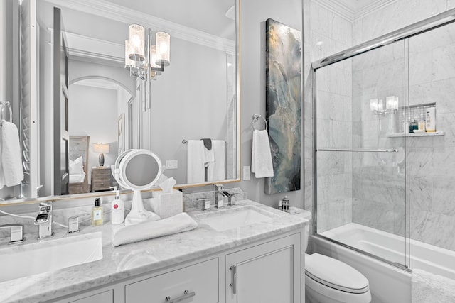 full bath with toilet, double vanity, ornamental molding, and a sink