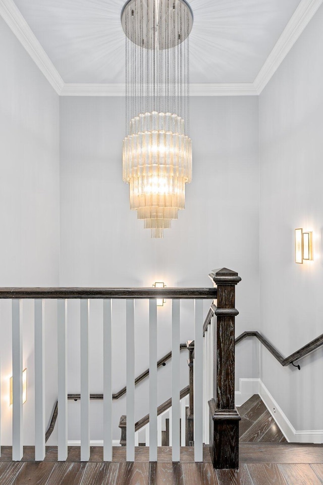 staircase with ornamental molding, baseboards, and an inviting chandelier