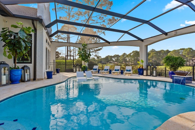 view of pool featuring glass enclosure, a fenced in pool, and a patio