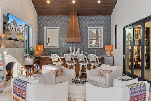 living area with a brick fireplace, wood ceiling, and recessed lighting