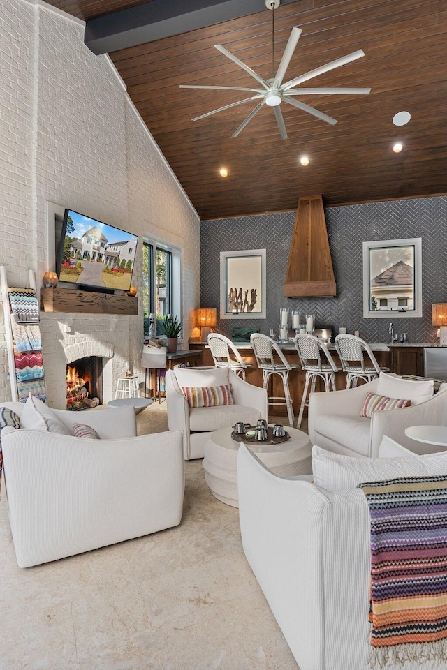 living area featuring wooden ceiling, a large fireplace, high vaulted ceiling, and wallpapered walls