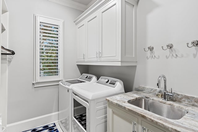 clothes washing area with cabinet space, washing machine and dryer, ornamental molding, and a sink