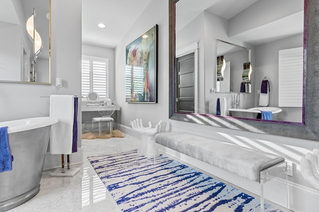 full bath with baseboards, marble finish floor, a freestanding tub, and recessed lighting