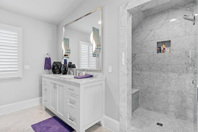 full bath with marble finish floor, baseboards, a tile shower, and vanity