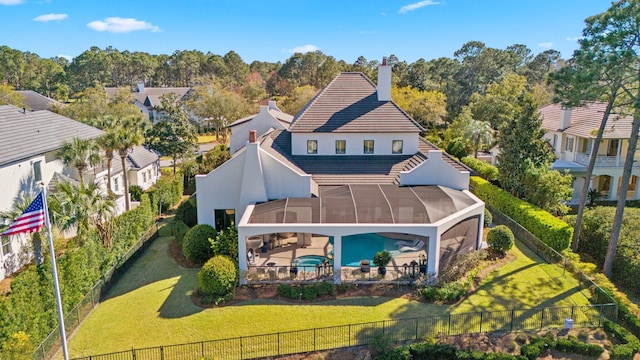 rear view of property with a tile roof, a patio, stucco siding, glass enclosure, and a fenced backyard